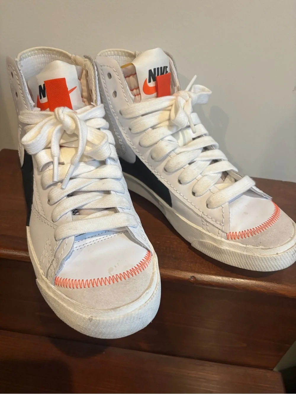 Nike White High-Top Sneakers with Black Swoosh and Orange Tongue Tab